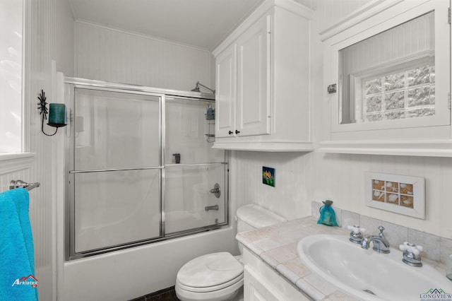 full bathroom with vanity, toilet, and combined bath / shower with glass door