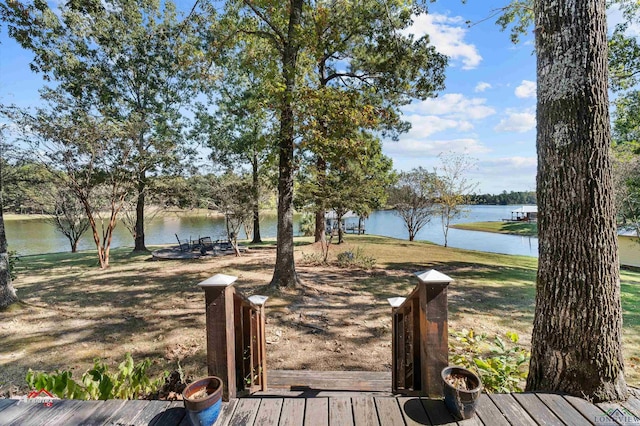 deck featuring a water view and a lawn