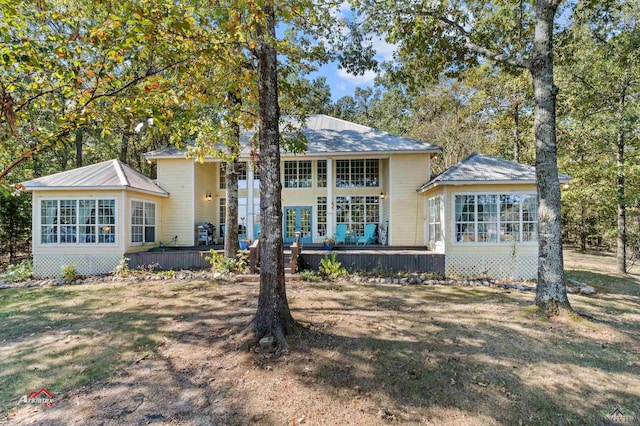 view of front of property featuring a sunroom and a deck