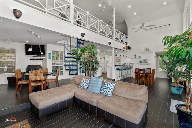 living room featuring ceiling fan and a high ceiling