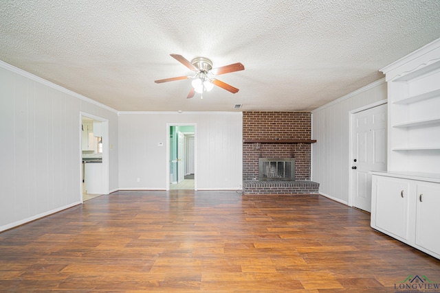 unfurnished living room with dark wood-type flooring, crown molding, a textured ceiling, ceiling fan, and a fireplace