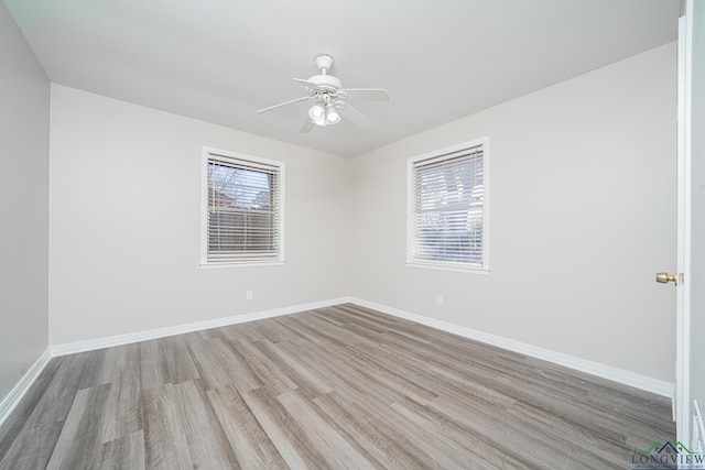 empty room with ceiling fan, a healthy amount of sunlight, and light wood-type flooring