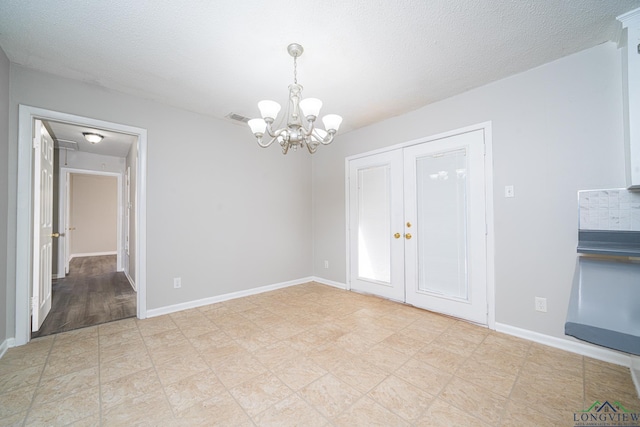 empty room with a chandelier and a textured ceiling