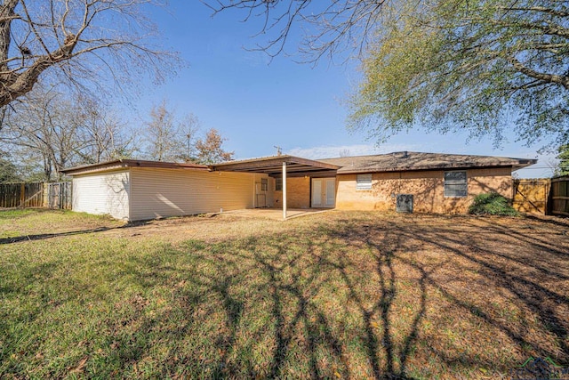 back of house featuring a lawn and a patio area