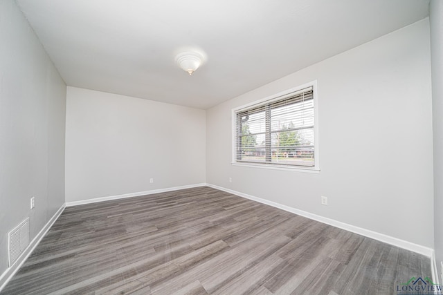 spare room featuring wood-type flooring