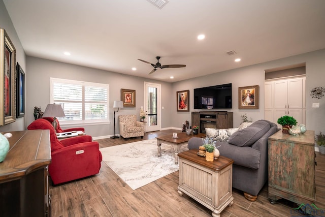 living room featuring ceiling fan and light hardwood / wood-style flooring