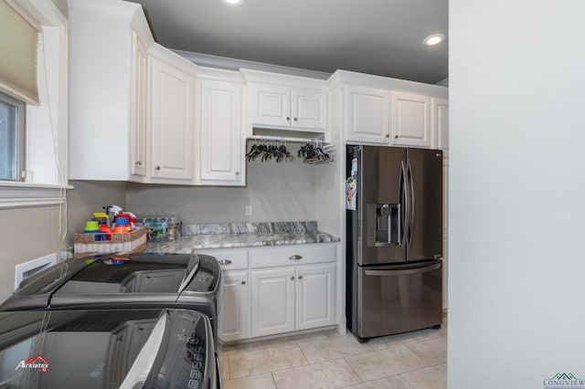 washroom with washing machine and clothes dryer and light tile patterned floors