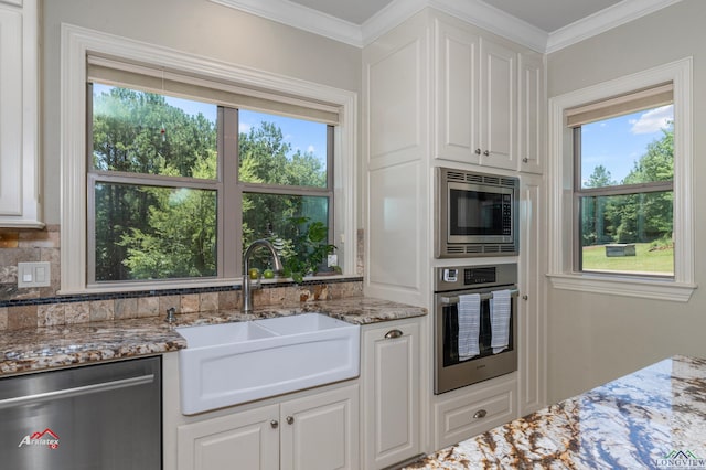 kitchen with light stone counters, white cabinetry, sink, and appliances with stainless steel finishes