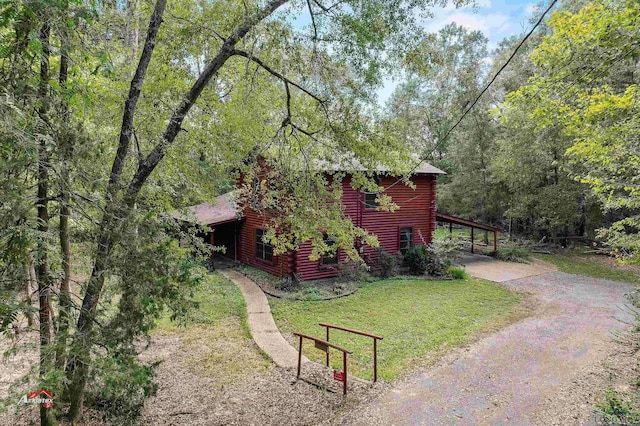 view of side of property featuring a carport and a lawn