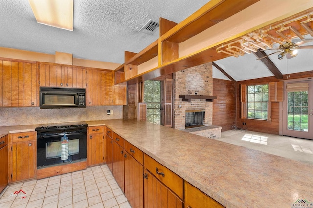 kitchen featuring ceiling fan, stove, vaulted ceiling, a fireplace, and light tile patterned flooring