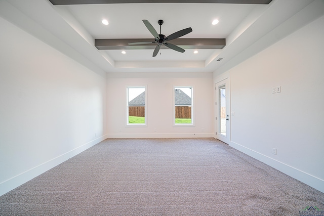 unfurnished room featuring a tray ceiling, ceiling fan, and light carpet