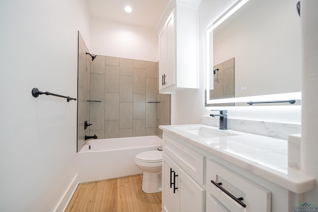 full bathroom featuring vanity, toilet, tiled shower / bath, and hardwood / wood-style flooring