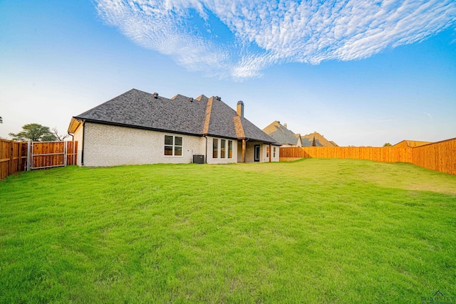 back of house featuring a yard and cooling unit