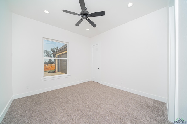 carpeted spare room featuring ceiling fan