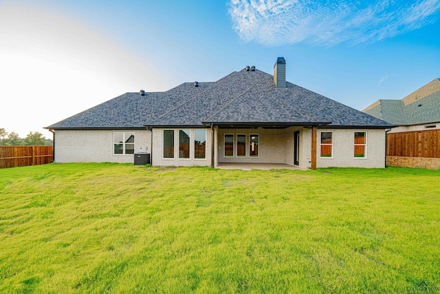 rear view of house with a lawn, a patio area, and central air condition unit