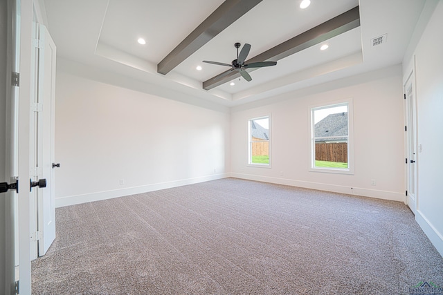 carpeted spare room with ceiling fan and a tray ceiling