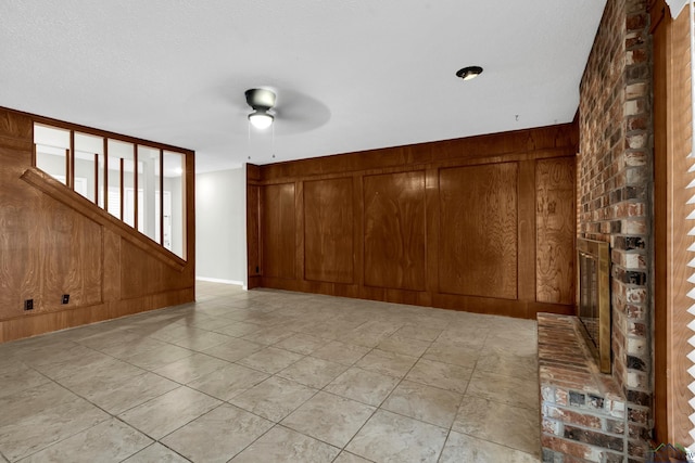 spare room with ceiling fan and wood walls