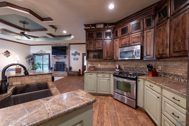 kitchen with ceiling fan, sink, stainless steel appliances, backsplash, and cream cabinets