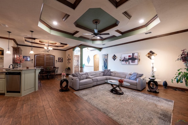 living room featuring ceiling fan with notable chandelier, dark hardwood / wood-style flooring, ornamental molding, and a tray ceiling