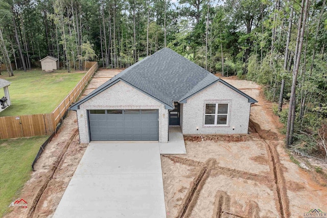 view of front of home with a garage, a front yard, and a storage unit