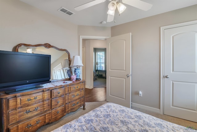 carpeted bedroom with ceiling fan, baseboards, and visible vents