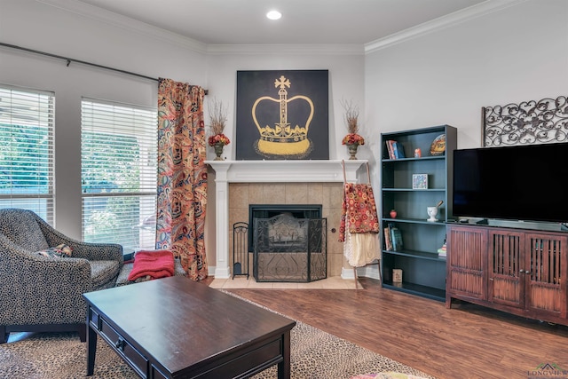living area featuring a tile fireplace, wood finished floors, recessed lighting, and crown molding