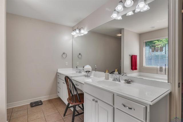 full bath with tile patterned floors, baseboards, a sink, and double vanity