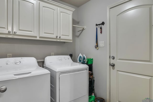laundry room with separate washer and dryer and cabinet space