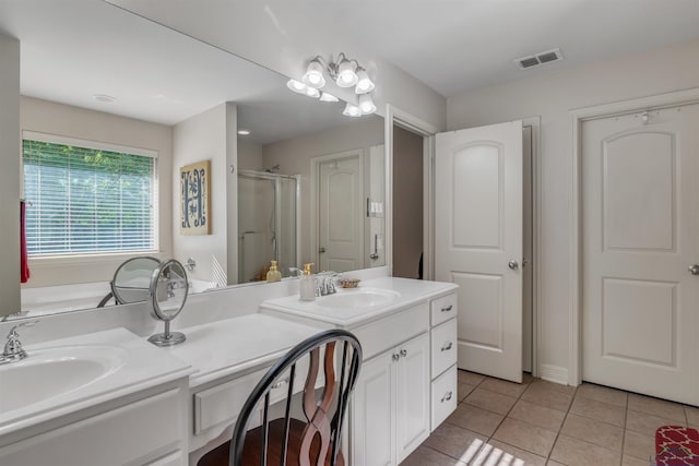 bathroom with tile patterned floors, visible vents, a sink, and double vanity