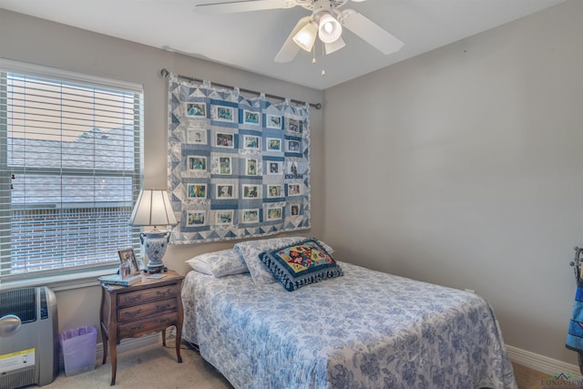 carpeted bedroom featuring baseboards and ceiling fan