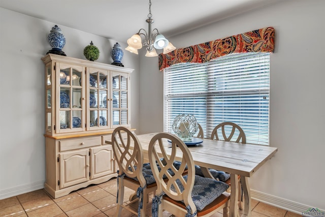 dining space with an inviting chandelier, baseboards, and light tile patterned floors