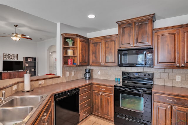 kitchen with a ceiling fan, a sink, black appliances, decorative backsplash, and arched walkways