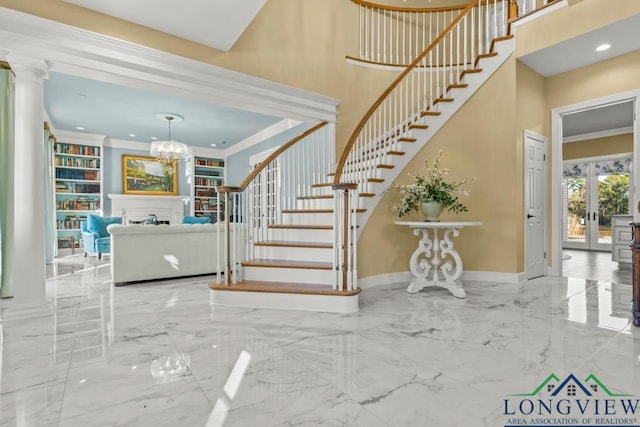 foyer entrance with decorative columns, crown molding, a towering ceiling, and french doors