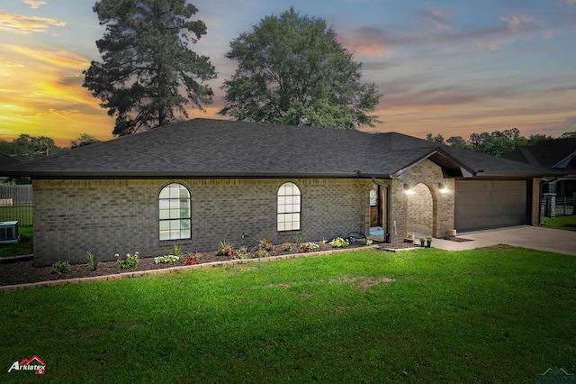 ranch-style home with brick siding, an attached garage, concrete driveway, and a shingled roof
