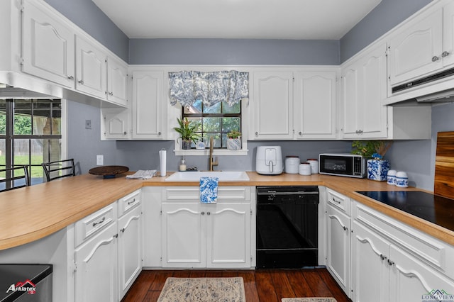 kitchen with black appliances, a sink, plenty of natural light, and white cabinets