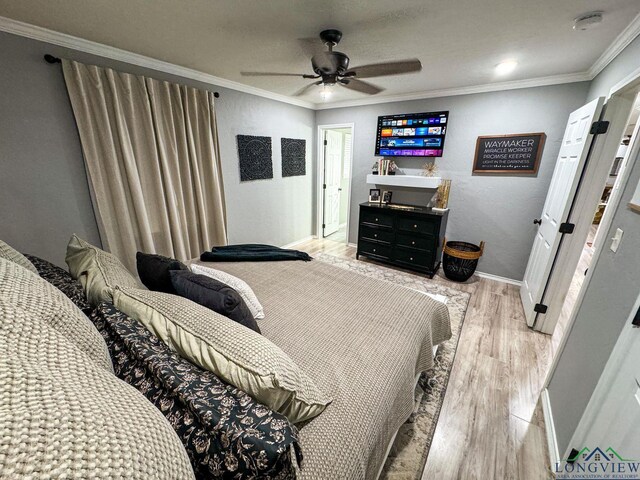 bedroom featuring a ceiling fan, crown molding, baseboards, and light wood-type flooring