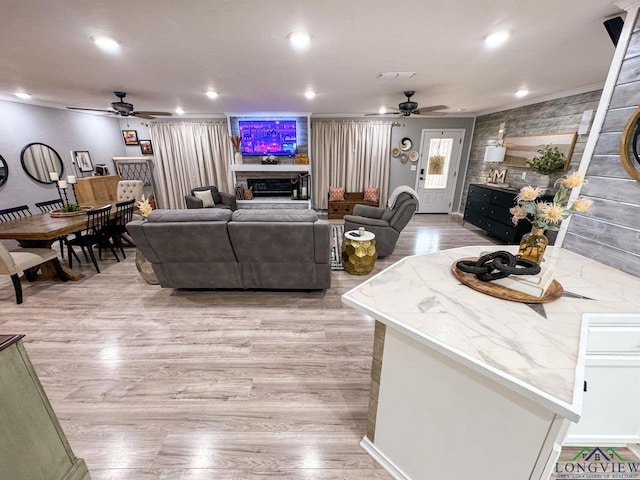 living area with visible vents, recessed lighting, a fireplace, light wood-style floors, and a ceiling fan