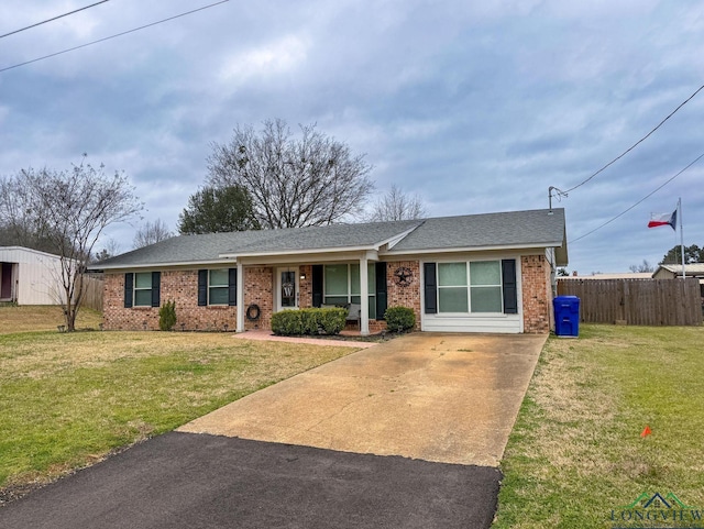 single story home featuring driveway, a front lawn, fence, a shingled roof, and brick siding