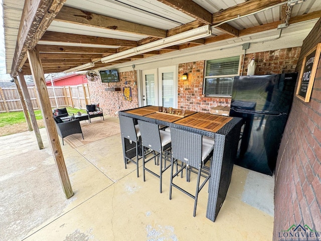 view of patio / terrace with outdoor dry bar and fence