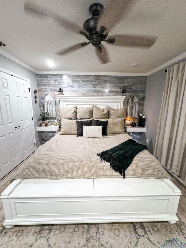 bedroom featuring a textured ceiling, ceiling fan, and ornamental molding