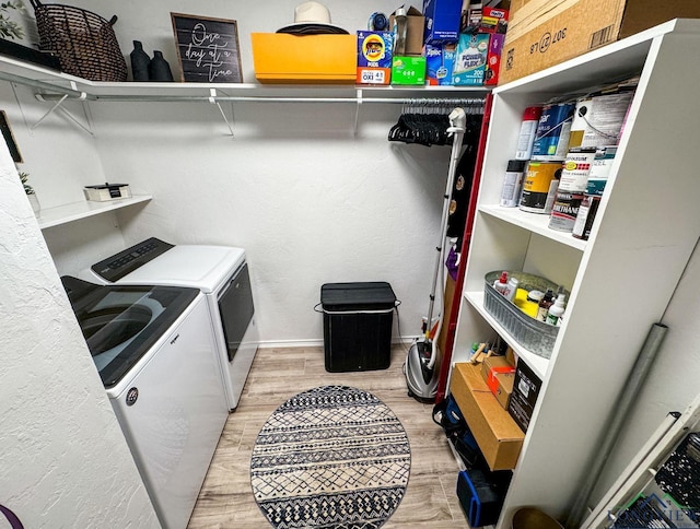 laundry area featuring light wood-style flooring, washing machine and dryer, and laundry area