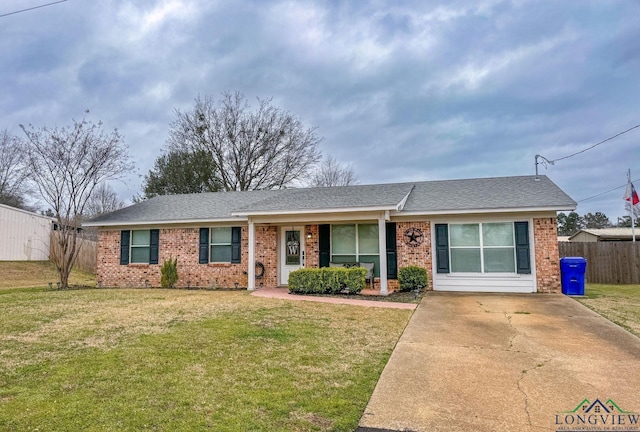 single story home featuring brick siding, a shingled roof, a front lawn, and fence