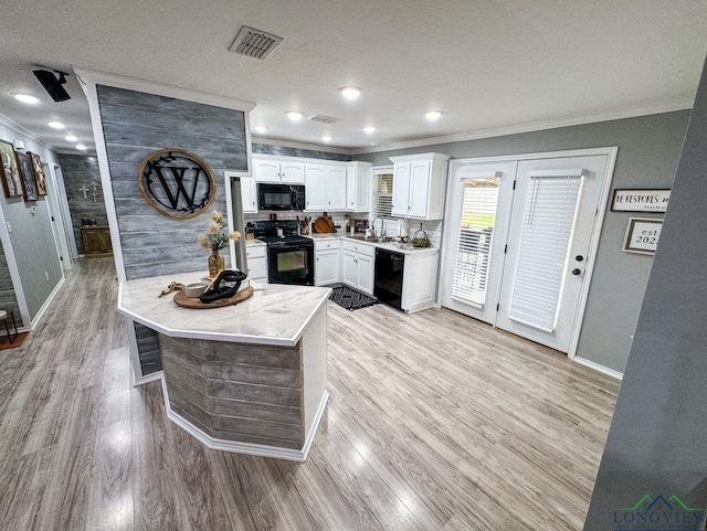 kitchen with visible vents, black appliances, ornamental molding, and white cabinets