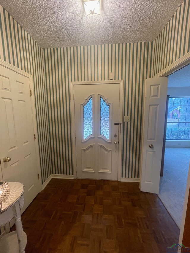 entryway featuring a textured ceiling and dark parquet floors