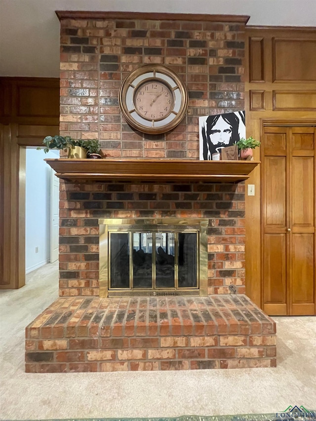 room details with carpet, wood walls, and a fireplace