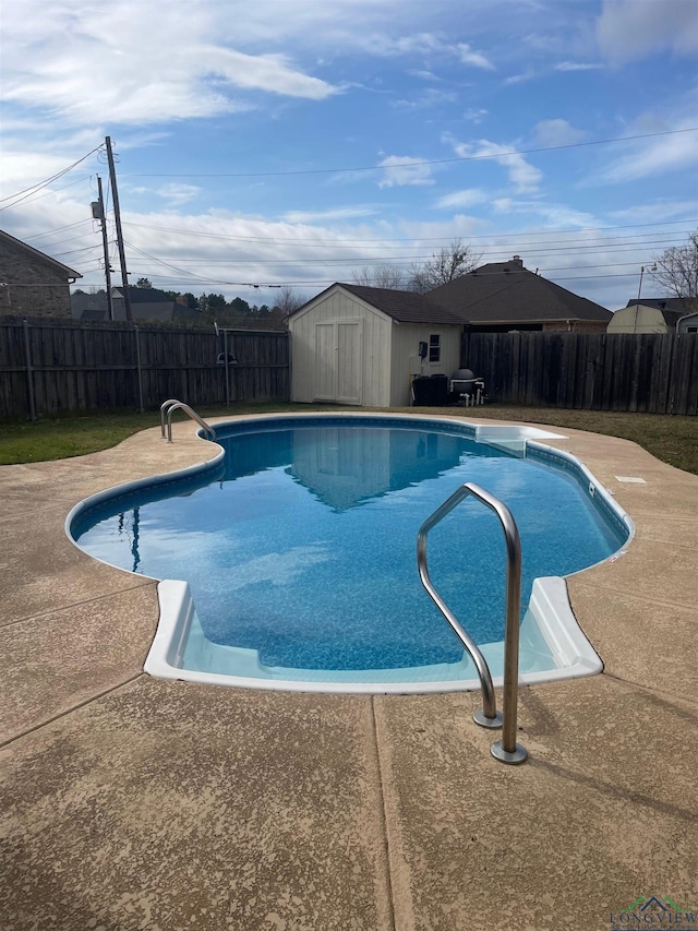 view of pool with a patio area and a storage unit