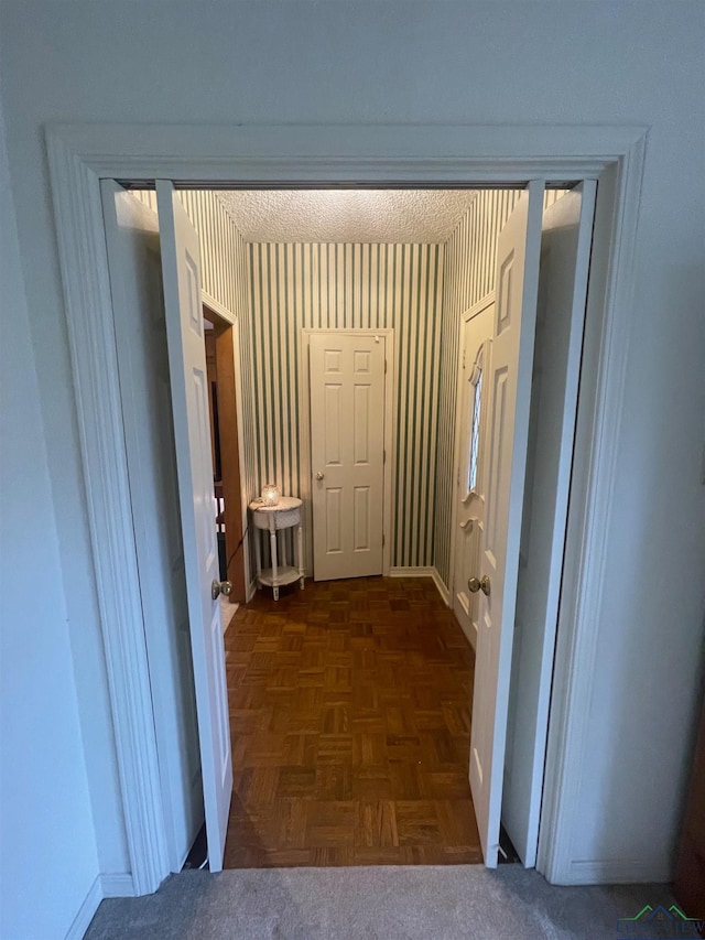 hallway featuring dark parquet flooring