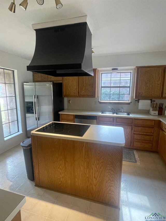 kitchen featuring a kitchen island, exhaust hood, sink, and a wealth of natural light