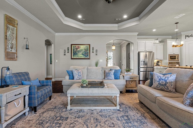 159 Jacobin Creek Dr, Gilmer, TX 75645 - living area featuring arched walkways, ornamental molding, a tray ceiling, wood finished floors, and recessed lighting