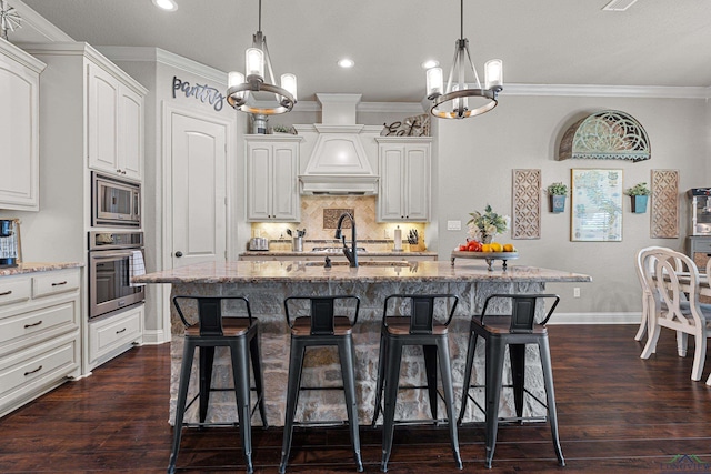 159 Jacobin Creek Dr, Gilmer, TX 75645 - kitchen with stainless steel appliances, a chandelier, light stone counters, a breakfast bar, and tasteful backsplash